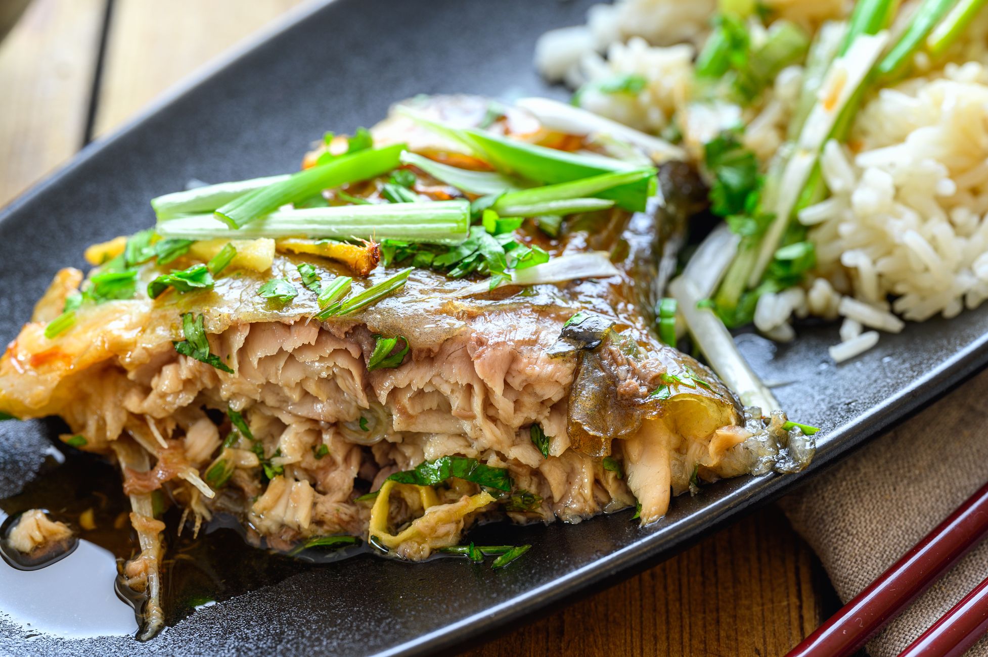 一盘清蒸鱼,上面铺着姜丝和葱段,色泽清淡