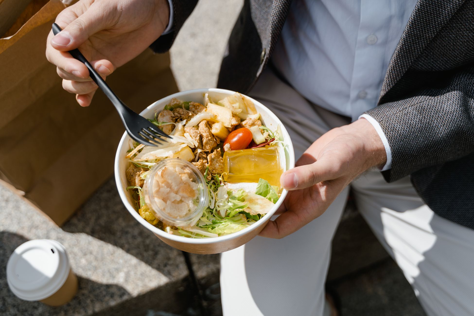 上班族在办公室食用包含深色蔬菜和杂粮的健康沙拉碗