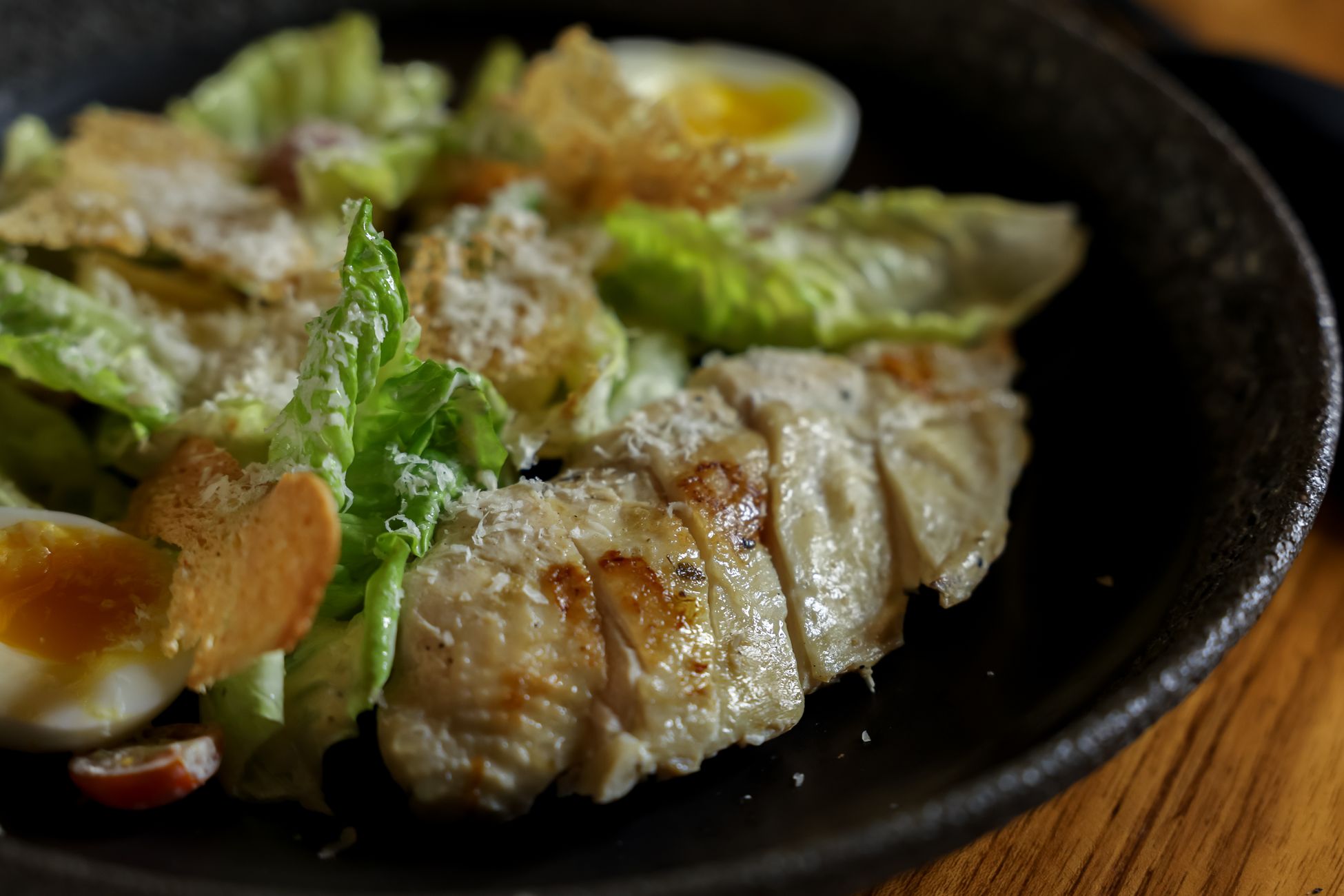 盘子里摆放着煎鸡胸肉和水煮蛋,代表高蛋白食物来源