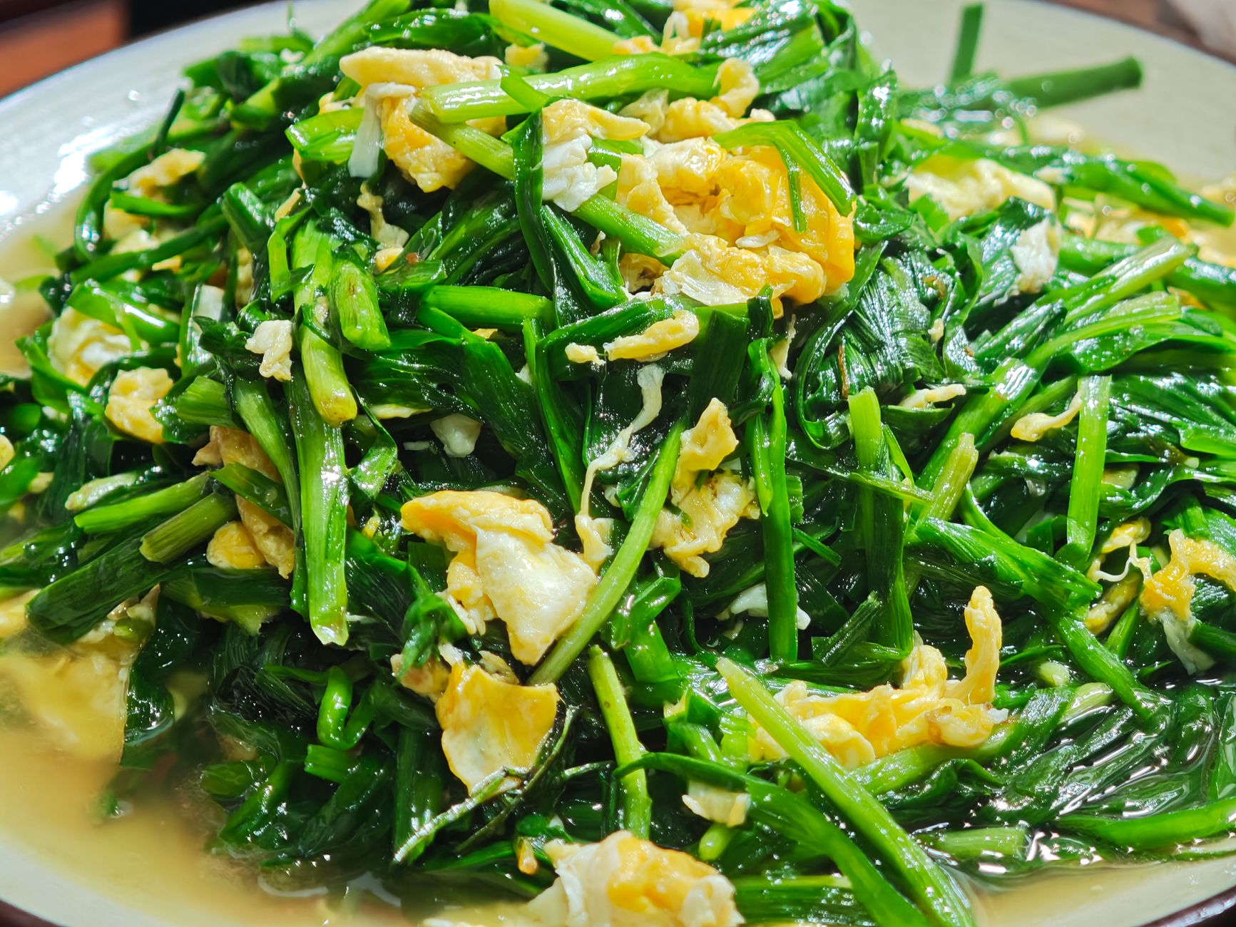 一盘清炒菠菜，深绿色叶片保留完整，是补充维生素 B2 的优质来源