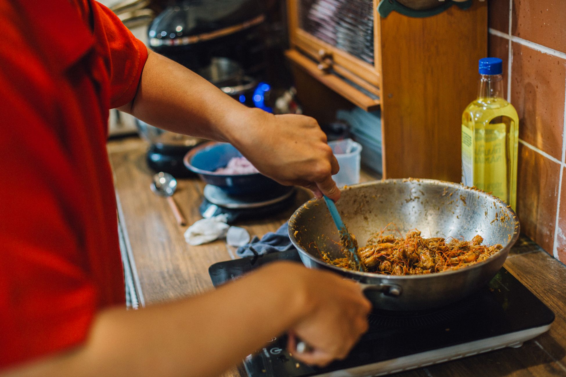 厨师在炒锅中倒入大量食用油进行烹饪