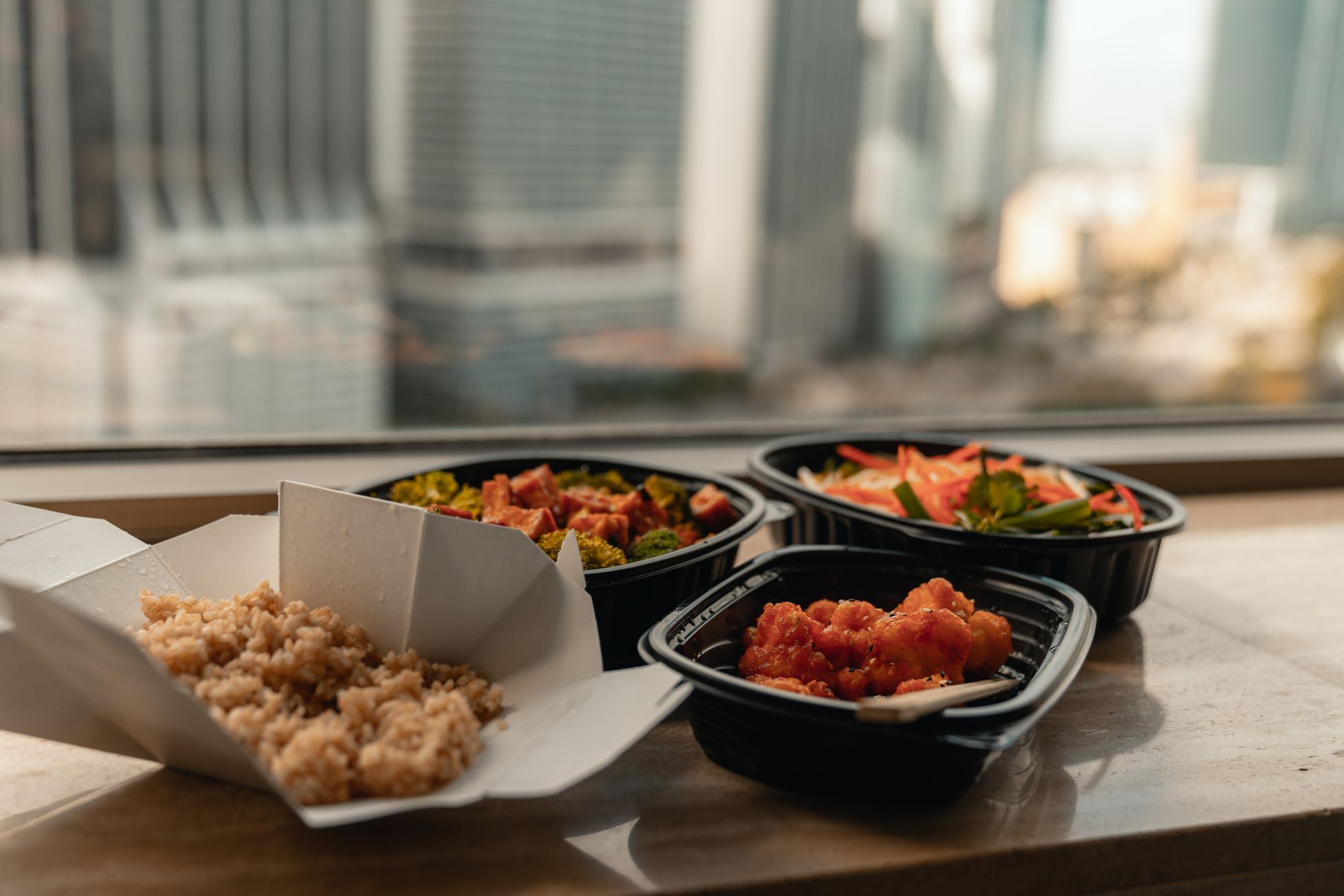 几份典型的外卖餐盒,包含米饭和少量烹饪过的蔬菜