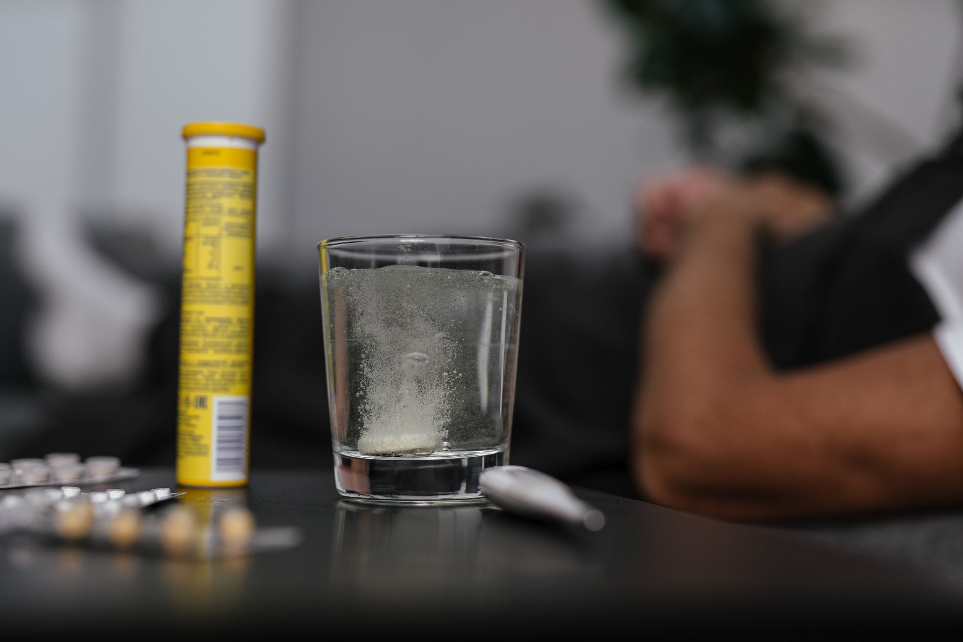 一杯清水旁边放着一瓶膳食补充剂，强调补水的重要性